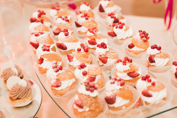 Delicious and tasty dessert table with cupcakes shots at reception closeup