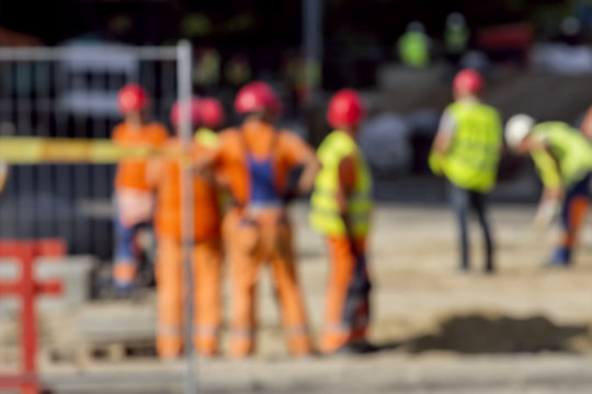 Builders workers in construction site. The photo is purposely made out of focus, no faces are recognisible.
