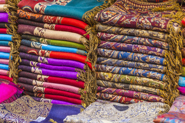 Colorful fabrics and carpets for sale on a street in Medina of E
