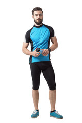 Bearded young adult cyclist with water bottle looking at camera. Full body length portrait isolated over white studio background.