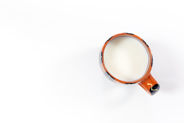 Milk in traditional rural Mug on white Table close up