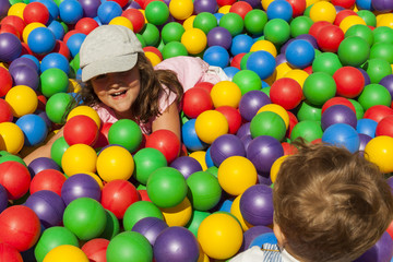 Fototapeta na wymiar Brother and sister playing in a ball pool