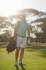 Full length of golf player carrying bag 