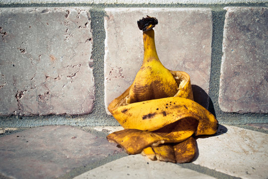 A depressed banana peel is leaning against the wall.