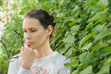 thinking young woman holding glasses