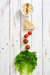 Vegetarian falafels and vegetables on a white wooden background

