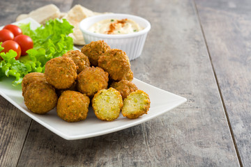 Vegetarian falafels and hummus on a rustic wooden table

