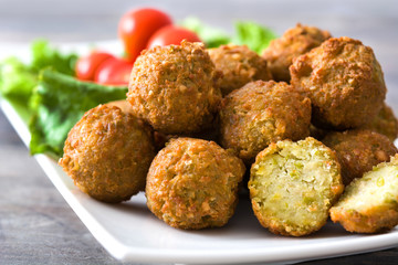 Vegetarian falafels and vegetables on a rustic wooden table

