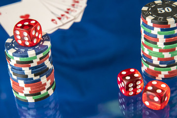 Gambling chips and poker card on blue mirror background