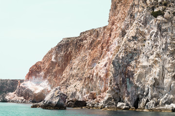 Fototapeta na wymiar Multicolored rocks into the aegean sea in Milos island, Greece