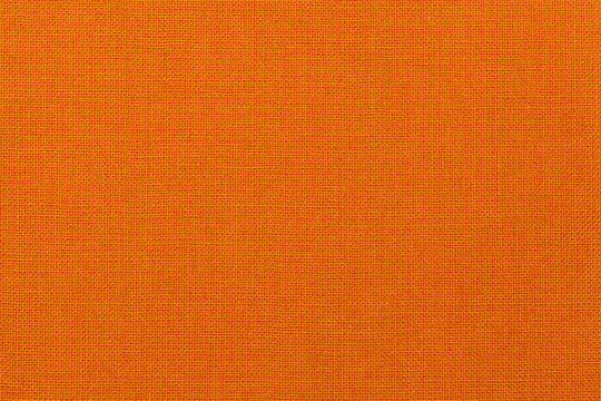 Bright orange background from textile material. Fabric with natural texture.