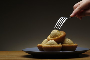 Hand holding a fork about to poke freshly baked Filipino muffin