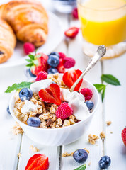 Muesli with yogurt and berries on a wooden table. Healthy fruit and cereal brakfast.