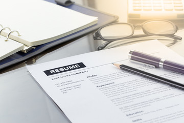 Resume information with pen, pencil, calculator, notebook, and glasses.