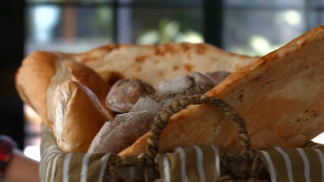 Rotating basket with bread loaves. Differrent buns and bread. Best products from local bakery. Food made with love.