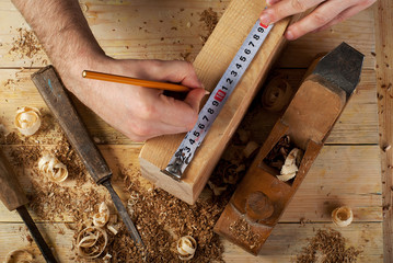 Carpenter working, hammer, meter and screw-driver on construction background