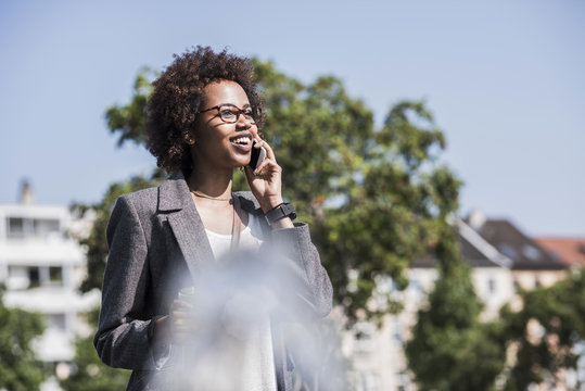 Portrait of smiling woman telephoning with smartphone
