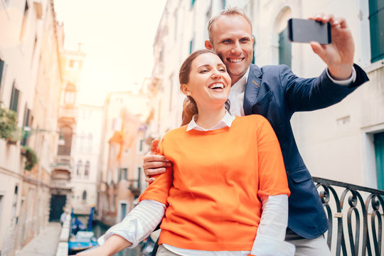 Happy smiling couple take a selfie photo on the old Venice stree
