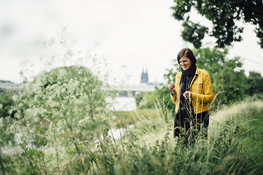 Germany, Cologne, happy woman standing on a meadow