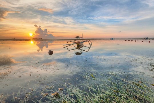 Holiday in Bali, Indonesia - Reflection Sunrise in Tanjong Benoa with boat