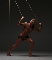 Young naked man, muscular body, bounded with rope