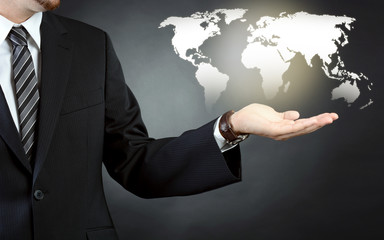 Geschäftsmann in Business Anzug hält Weltkarte als Symbolbild für Globalisierung und...
