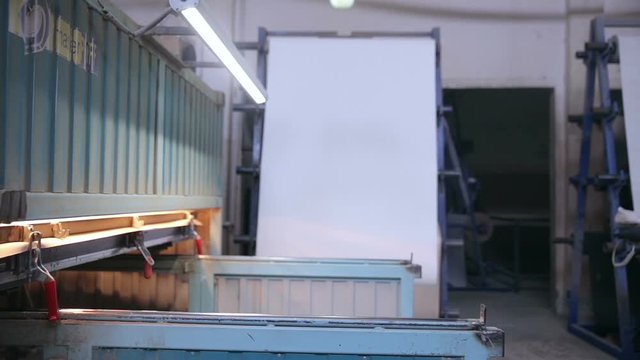 Man puts wooden door into automated Hydraulic press. 1080p.