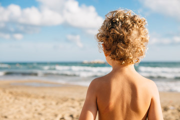 Back view of topless kid on beach © click_and_photo