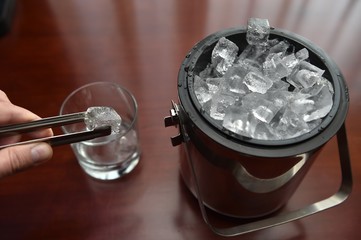 Ice cubes in the bucket and tongs next to it