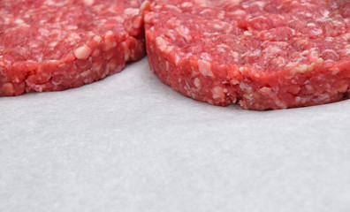 Raw meat burgers for hamburgers on parchment