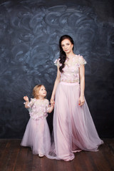 Fototapeta na wymiar Portrait of mother and daughter in identical dresses. Familylook