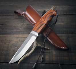 hunting knife handmade on a wooden background
