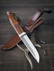 hunting knife handmade on a wooden background