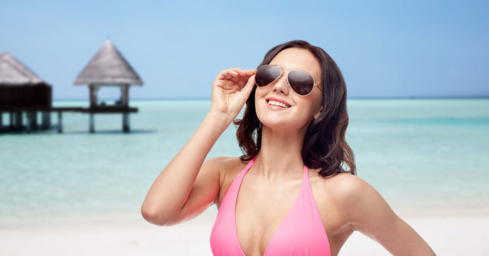 happy woman in sunglasses and bikini on beach