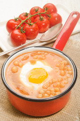 baked beans with fried egg in a red enamel pot
