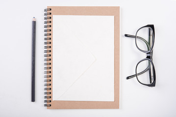 blank paper on notebook with pencil and eyeglasses