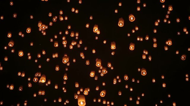 Thousand of sky lanterns in the night sky during Yee Peng Festival in Thailand