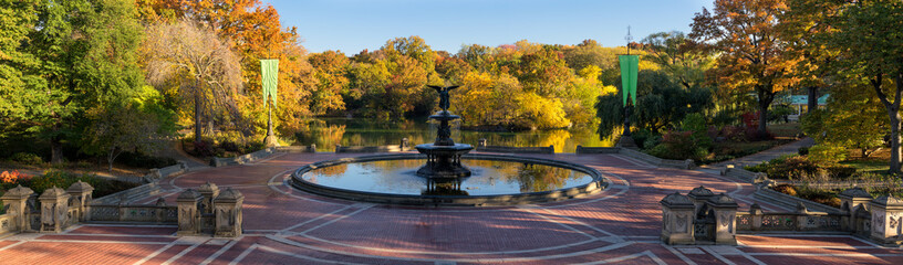 Obraz premium Wschód słońca w Central Parku przy fontannie Bethesda z jeziorem i kolorowymi jesiennymi liśćmi. Panoramiczny widok na Bethesda Terrace, Manhattan, Nowy Jork