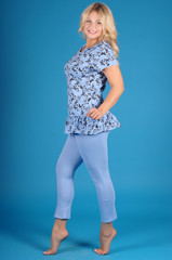 Beautiful young girl posing in street clothes on blue background.Isolated studio portrait