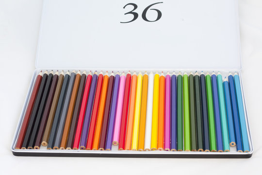 Set of colored pencils in a box on a white background
