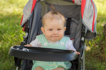 little girl sitting in a baby carriage