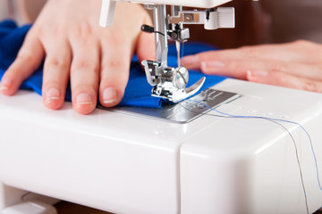 Young woman sewing fabric