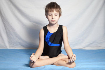 The young boy practices yoga