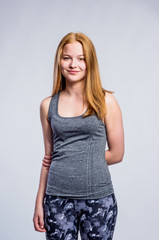 Girl in gray singlet and fitness leggings, studio shot