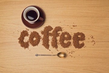 Coffee background with coffee cup and instant coffee letters. View from above