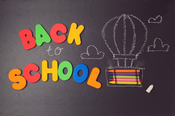 Back to school background with air balloon made from pencils and letters on black board