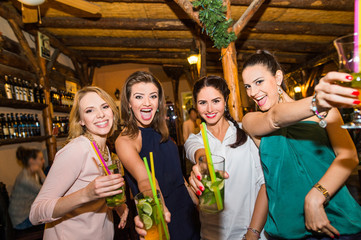 Young beautiful women with cocktails in bar or club