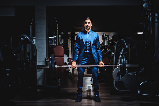 Man in suit lifting heavy weight