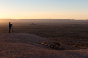 Fototapeta na wymiar photographer takes a photo with a tripod in Monument Valley
