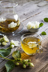 cup of green tea infused with jasmine on a gray wooden background